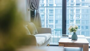 Ein stilvolles Wohnzimmer mit einer Couch, einem Couchtisch und einer Blumenvase.