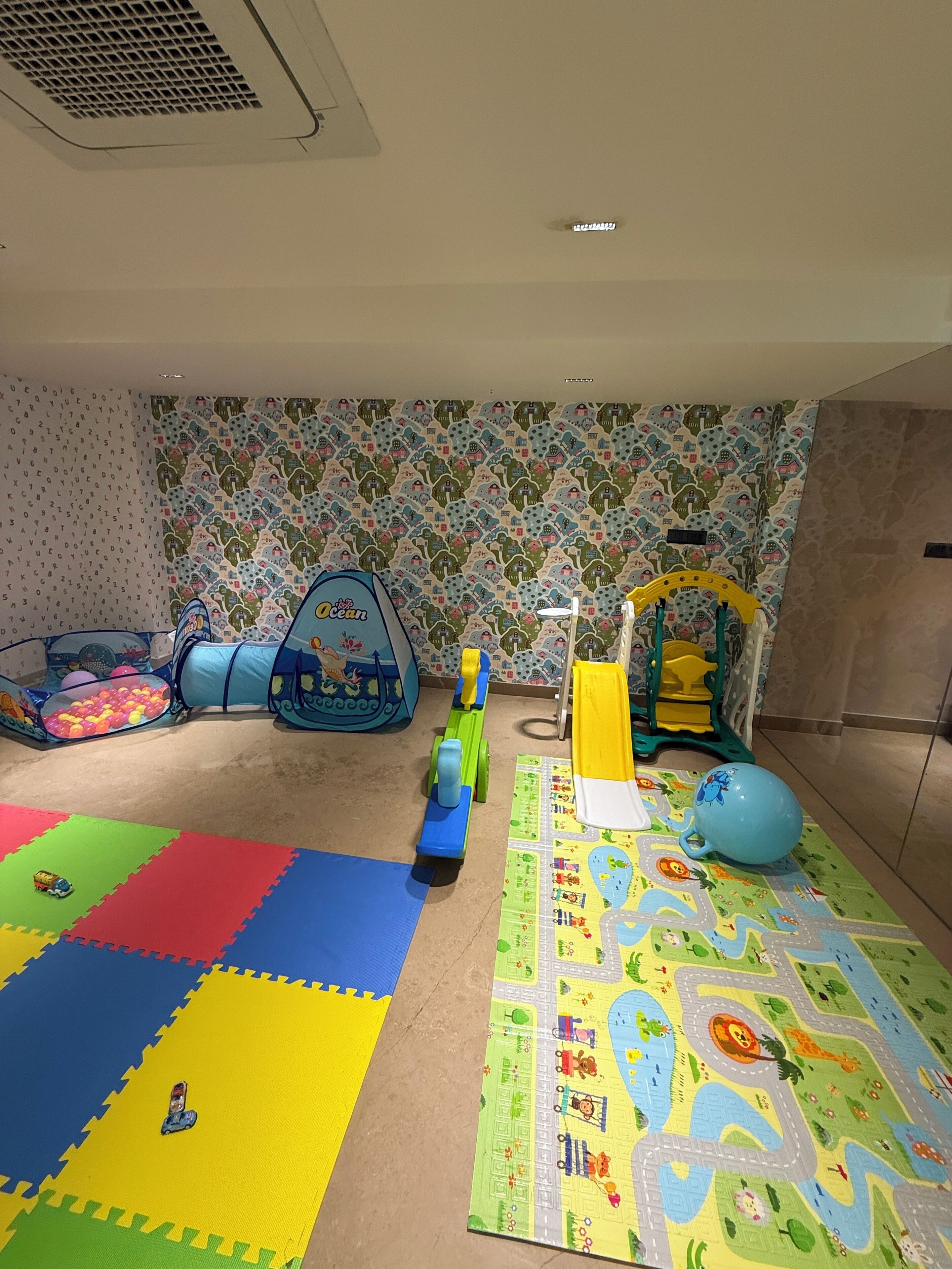 A play area with colorful mats, a ball pit, and a play structure.