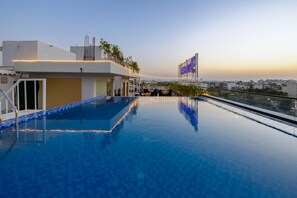 Ein Rooftop-Infinity-Pool mit Blick auf die Skyline der Stadt.