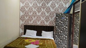 Una habitación de hotel con una cama, un papel tapiz estampado y una puerta decorativa.