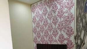 Un dormitorio con cama, pared estampada y panel decorativo.