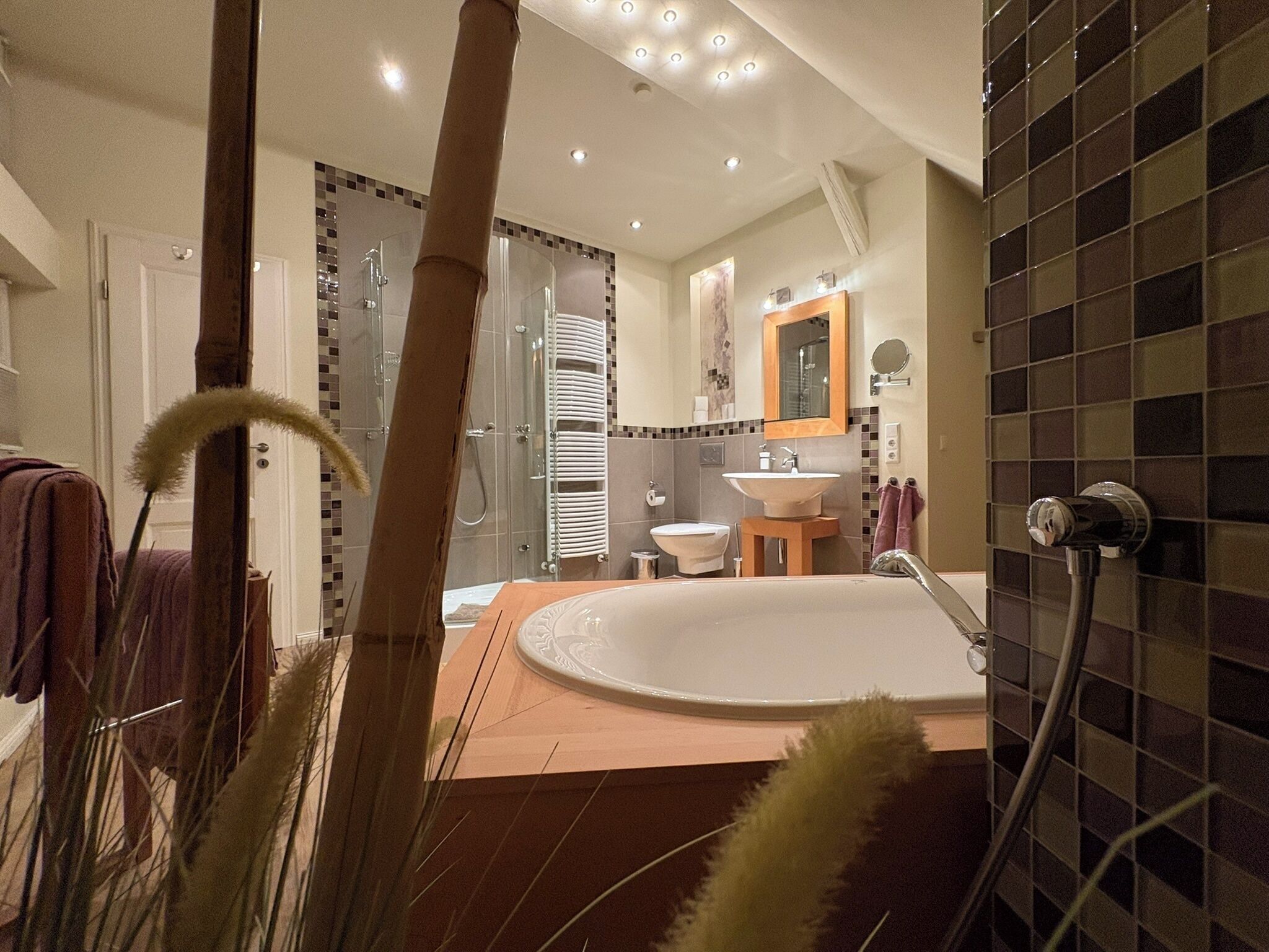 Ein modernes Badezimmer mit Badewanne, Waschbecken und Duschbereich.