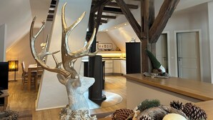 Een modern interieur met een houten plafond, een eethoek en een keuken op de achtergrond.