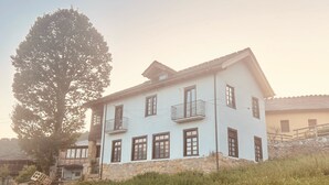 A two-story building with a stone foundation and multiple windows.