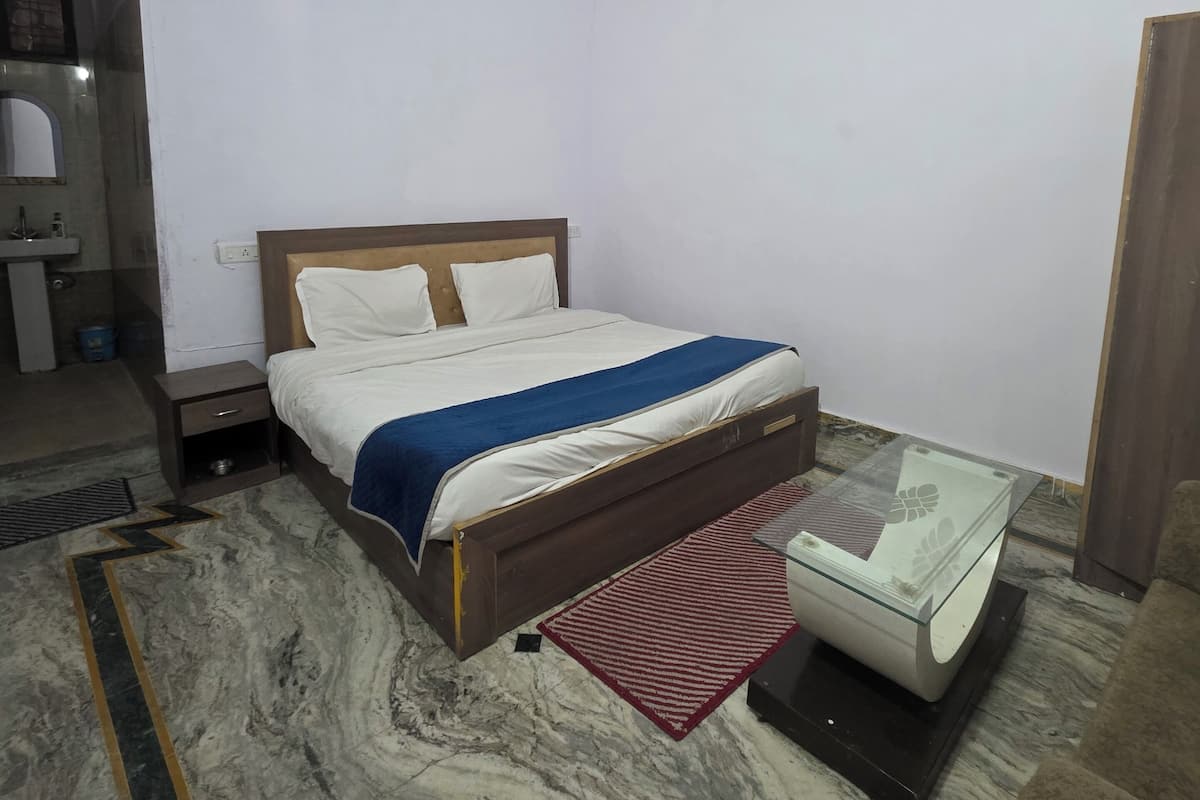 Une chambre à coucher comprenant un lit, un ventilateur de plafond, une table de chevet, une petite table et un canapé.
