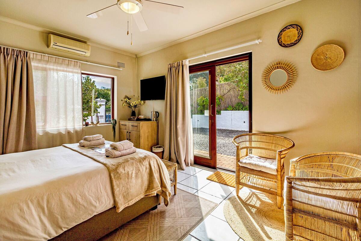 A bedroom with a bed, a desk, a chair, and a TV.