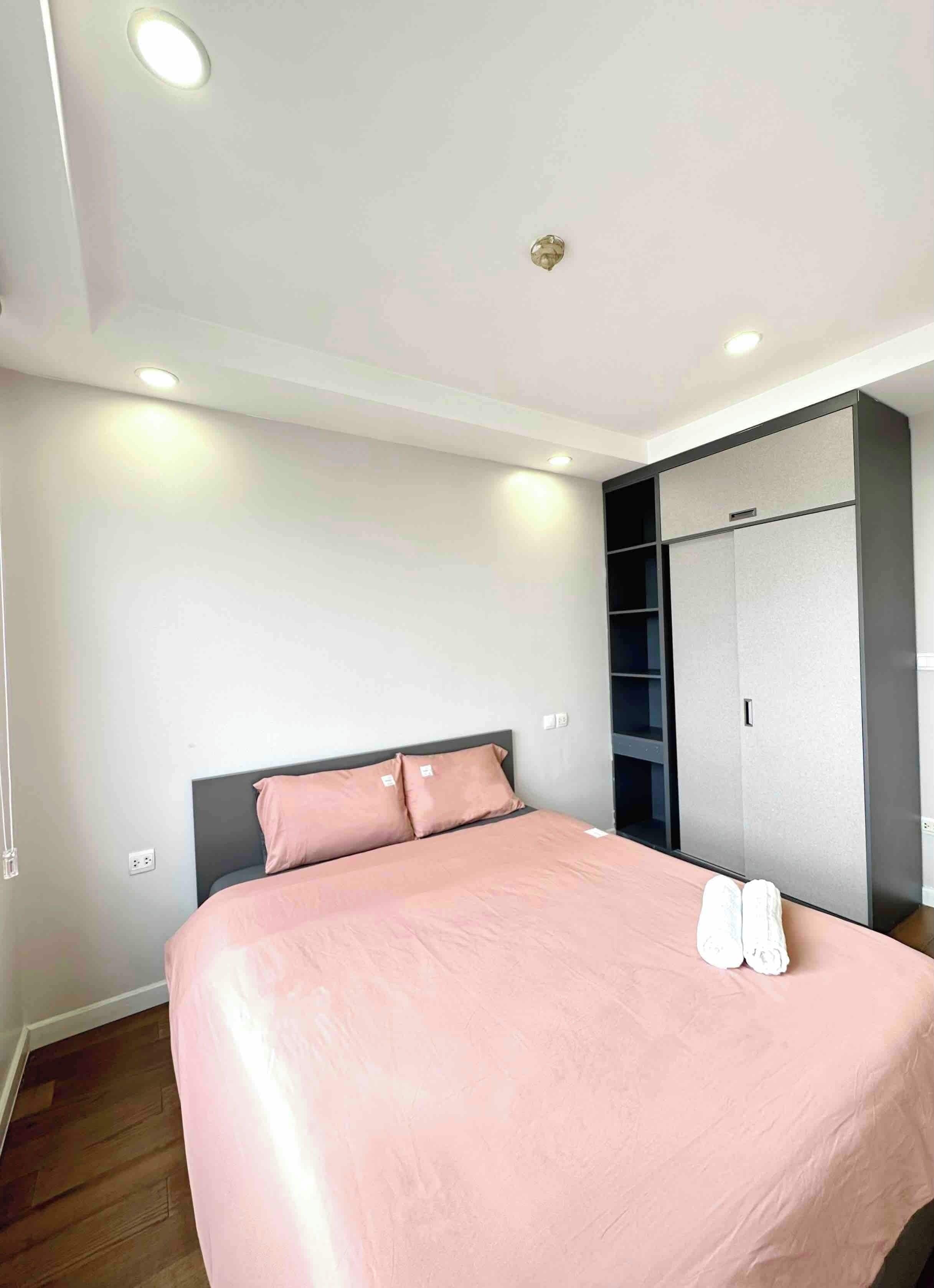 A bedroom with a bed, a wardrobe, and a ceiling light.
