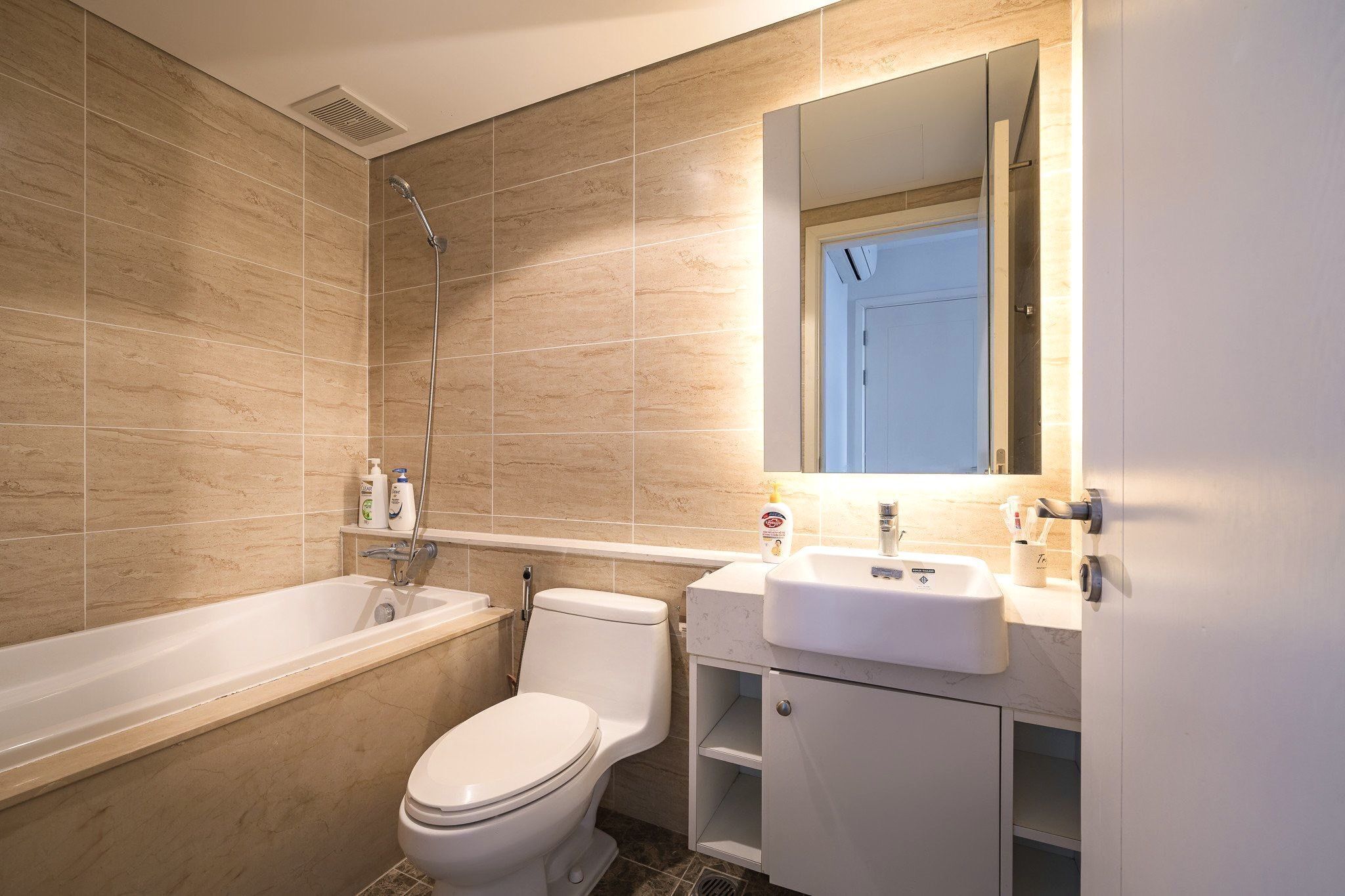 A modern bathroom with a bathtub, toilet, and sink.