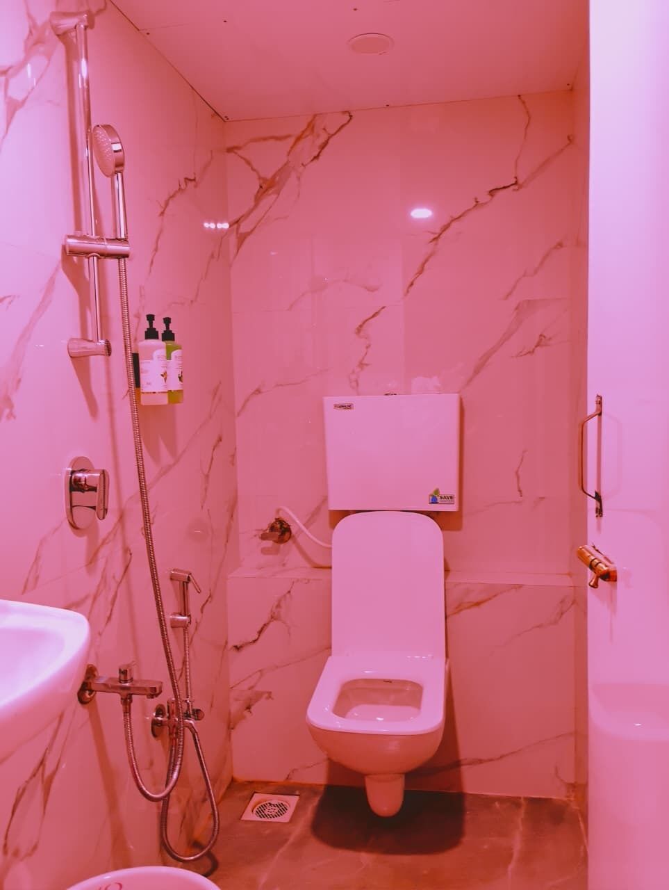 A bathroom with a toilet, a shower, and a sink.