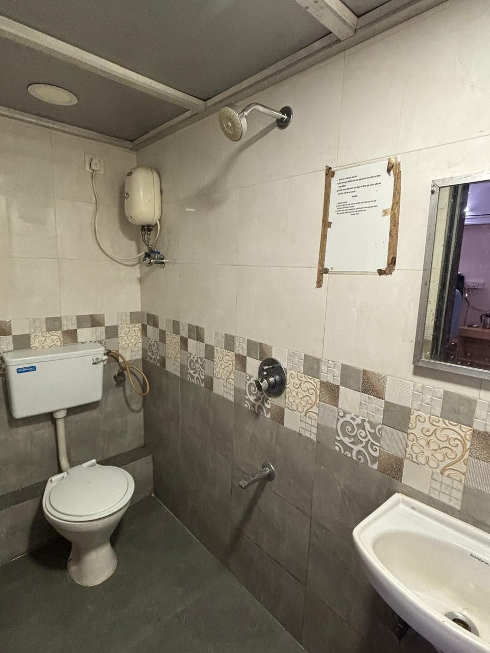 Een compacte badkamer met toilet, wastafel en douche.