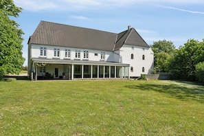 A large house with a covered patio and a lawn.