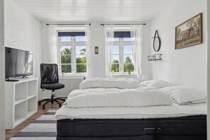 A bedroom with a bed, a desk, a chair, a TV, and windows. - Large holiday home near Tønder (Tønder)