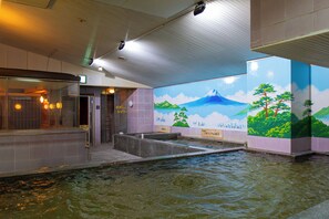 A public bath area with a mural of a mountain and trees, tiled walls, and a water feature. - Men's only Capsule Hotel Asahi Plaza Shinsaibashi (Osaka)