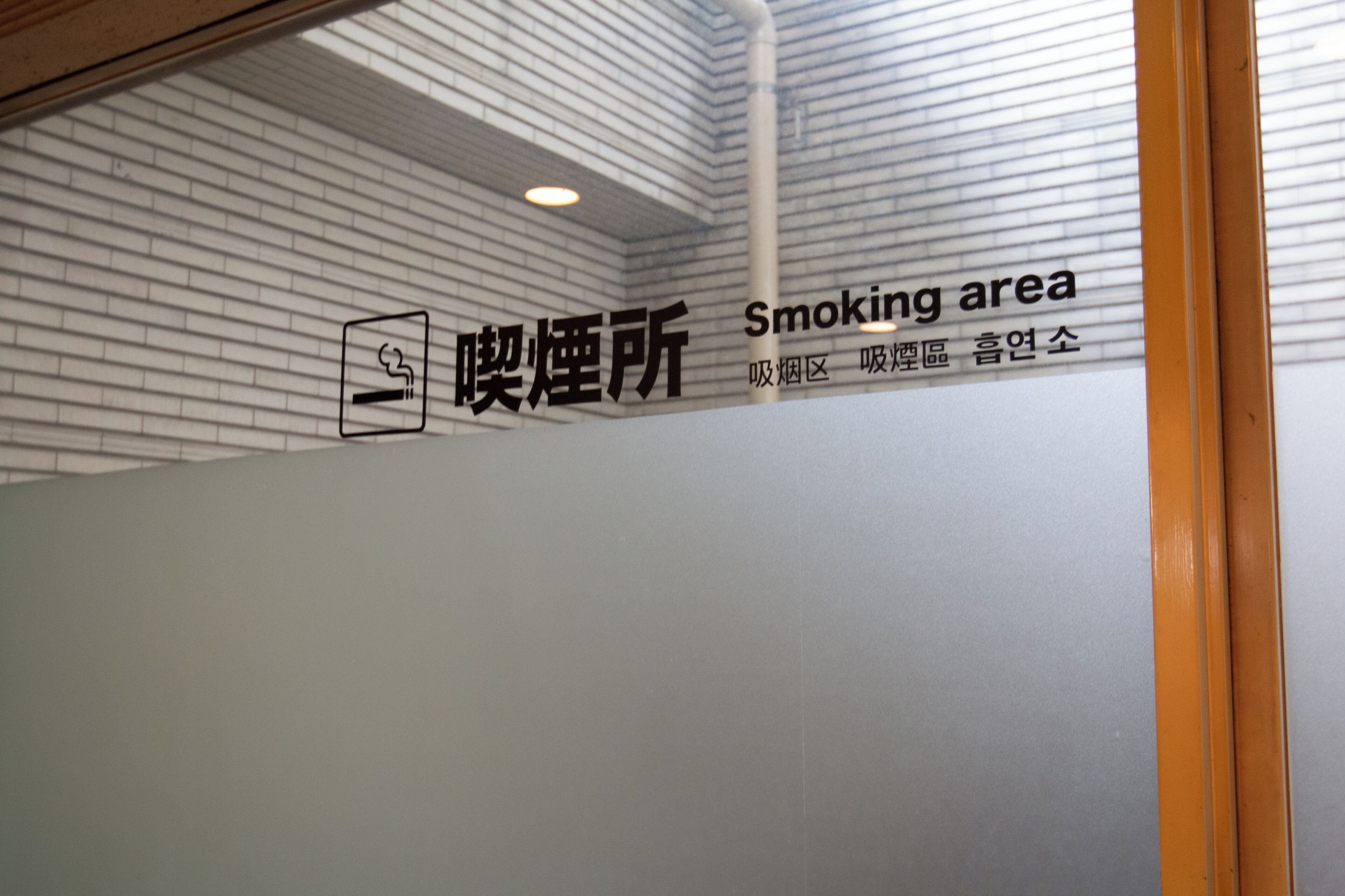 A wall with a sign indicating a smoking area.