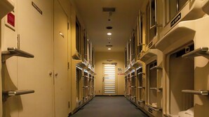 A narrow corridor with doors on both sides, leading to private rooms. - Men's only Capsule Hotel Asahi Plaza Shinsaibashi (Osaka)