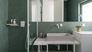 A modern bathroom with a large mirror, a white sink, and a shower area. - The Met Suite 3, elegant stay centrally in Rethymno! (Rethymno)