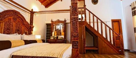 Una cama con dosel y tablero de madera, una escalera con barandilla de madera y un espejo grande en la pared.