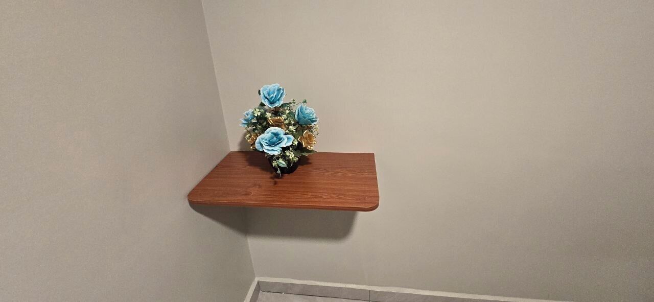 Una estantería de madera con un arreglo floral.