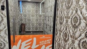 A hotel reception area with patterned wallpaper, a 'WELCOME' sign, and a marble-tiled floor. - Enrich Hotel Semenyih by uBook (Semenyih)