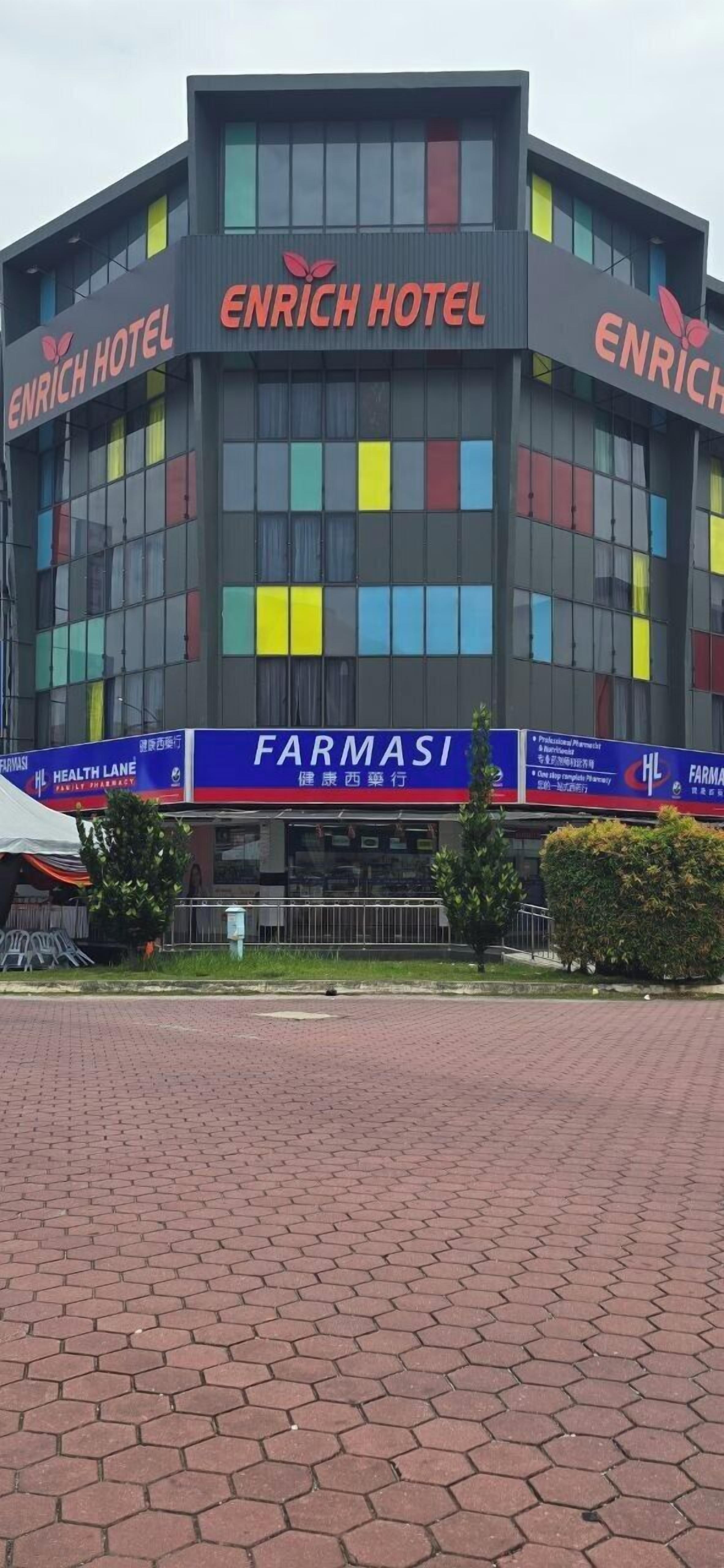 A building with a sign reading "ENRICH HOTEL" and a banner for "FARMASI".
