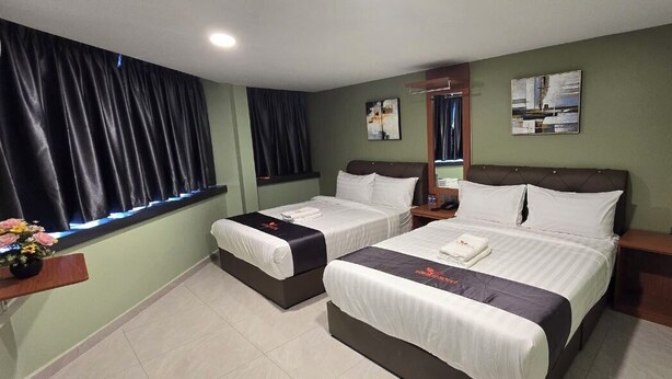 A hotel room with two single beds, a small table, a mirror, and a window with curtains. - Enrich Hotel Semenyih by uBook (Semenyih)