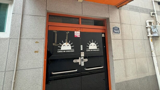 A hotel entrance with a sign reading "Sunrise Inn Dongdaemun." - Sunrise Inn (Seoul)