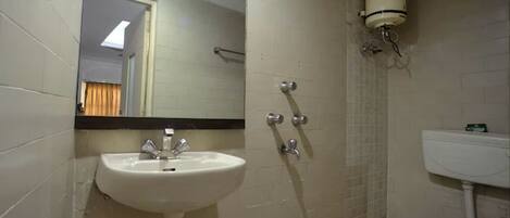 A bathroom with a sink, mirror, shower, and toilet.