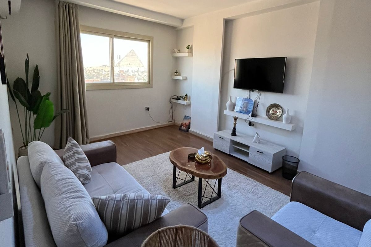 Un salon moderne comprenant un ensemble de canapés, une table basse et un téléviseur fixé au mur.