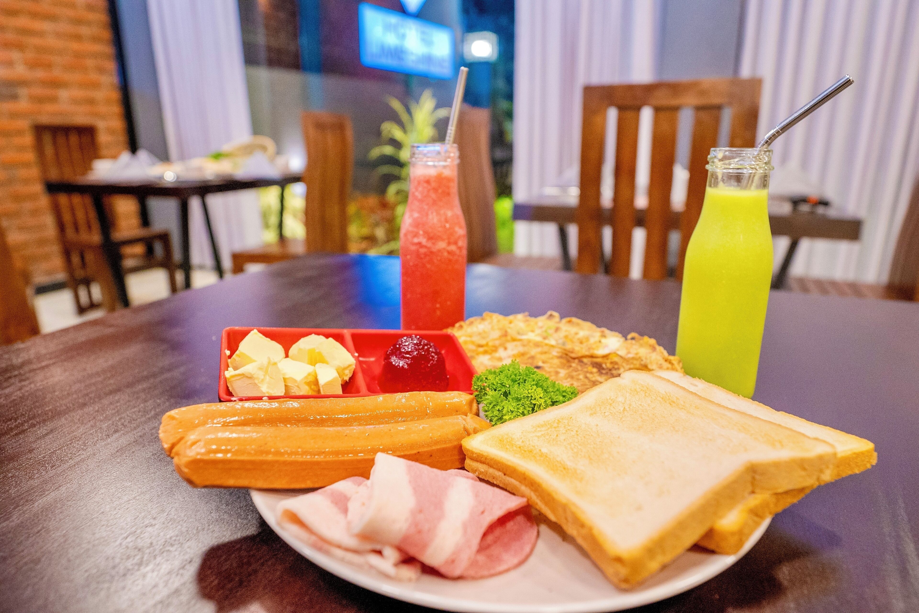 A plate with a sandwich, a drink, and a side of fruit and cheese.