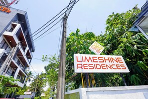 A sign for Limeshine Residences with a modern building in the background. - Limeshine Airport Transit Residence (Kurana,Katunayaka)