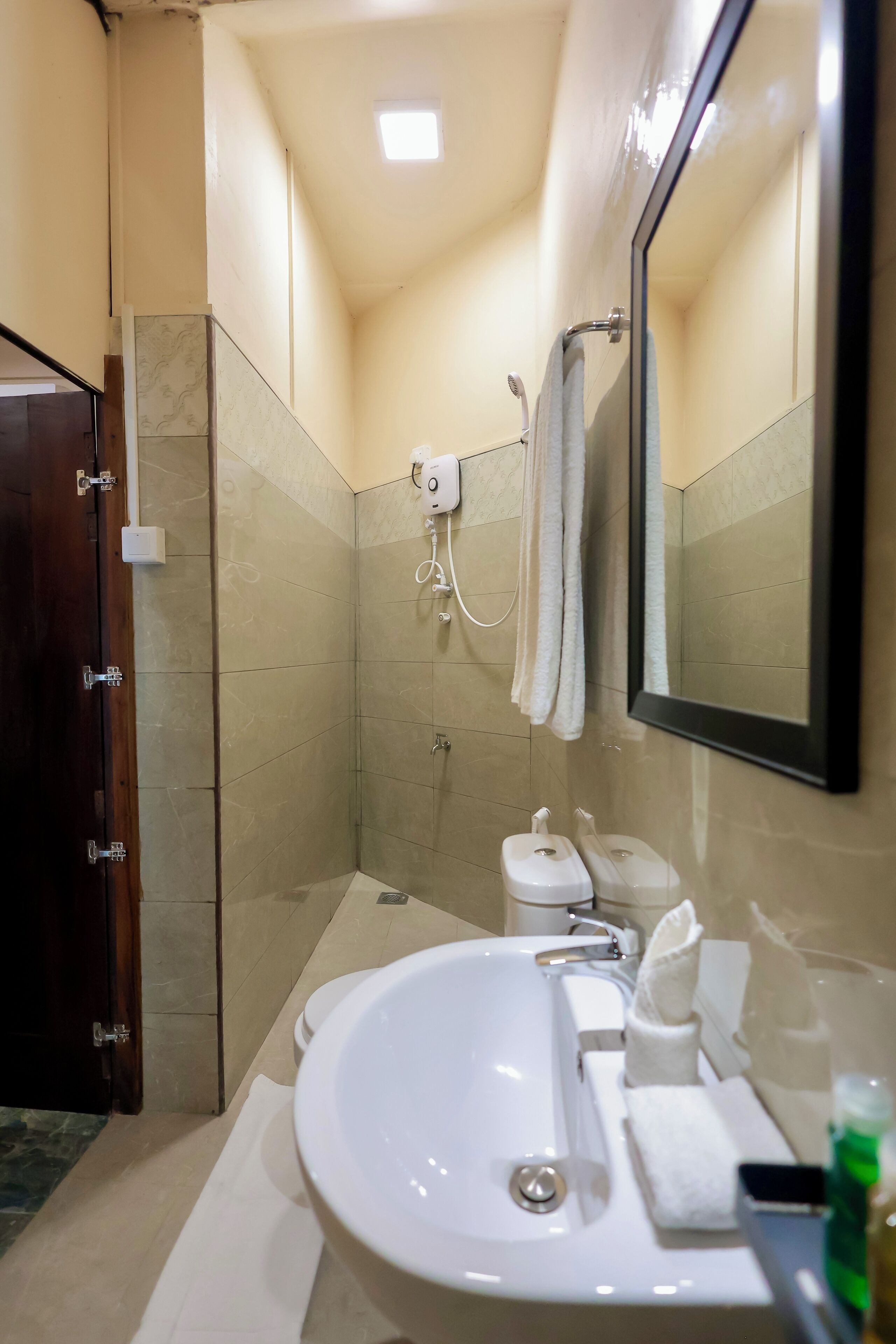 Une salle de bain équipée d’un lavabo, de toilettes, d’une douche et d’un miroir.