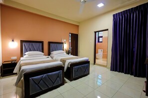 A hotel room with two beds, a ceiling fan, and a bathroom visible through a door. - Limeshine Airport Transit Residence (Kurana,Katunayaka)