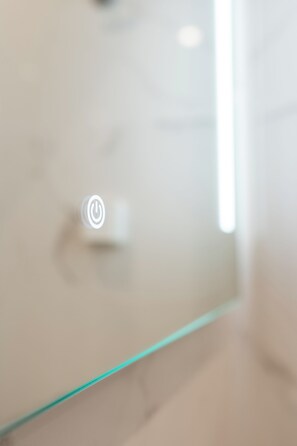 A close-up of a white wall with a power button symbol. - Charming 2 Bedroom House in Iraklio, Greece (Irakleio)