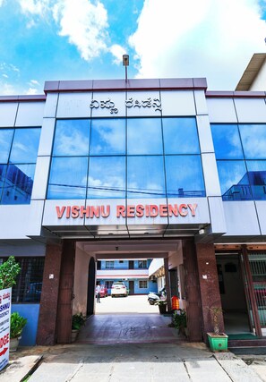 Der Eingang zum Vishnu Residency, mit blauem Himmel und einem Schild über dem Eingang.