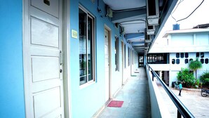 A corridor with doors, windows, and a balcony with a railing. - The Vishnu Residency (Chikkamagaluru)