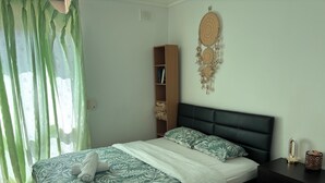 Ein Schlafzimmer mit Bett, Nachttisch, Ablagefläche und Wanddekoration.