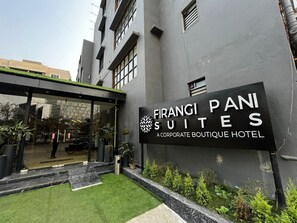 A sign for 'Firangi Pani Suites' indicating it is a corporate boutique hotel.