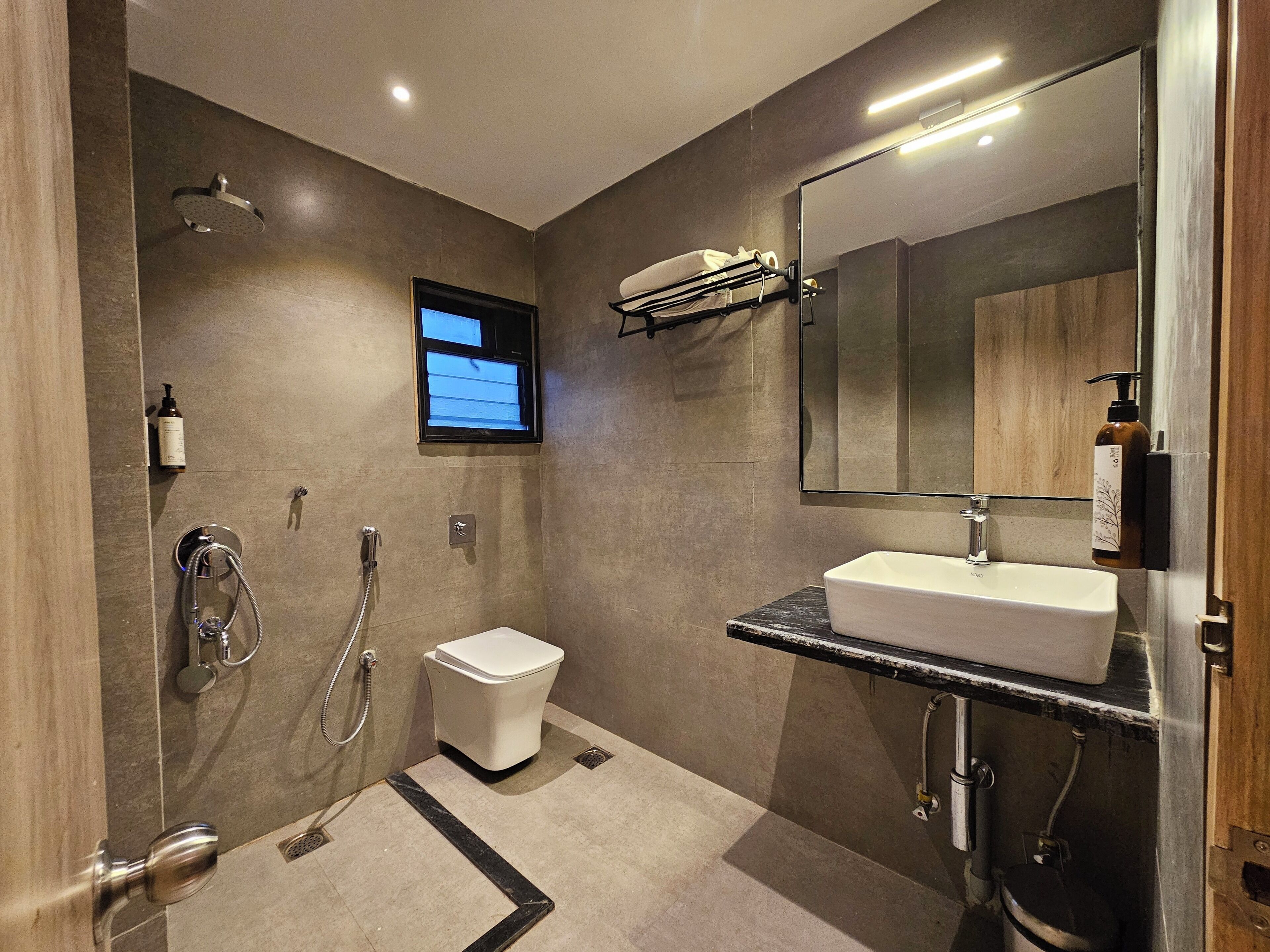 Une salle de bain moderne équipée d’une douche, de toilettes et d’un lavabo.