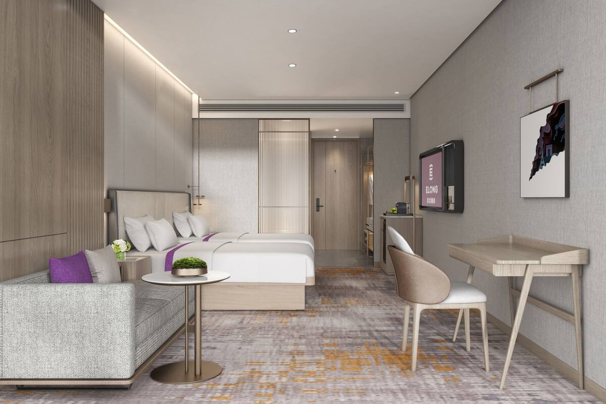 Quarto de hotel moderno com cama, sofá, escrivaninha e cadeira.