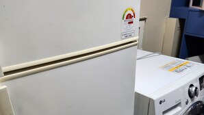 Eine weiße Waschmaschine mit Bedienfeld und Etikett an der Tür.