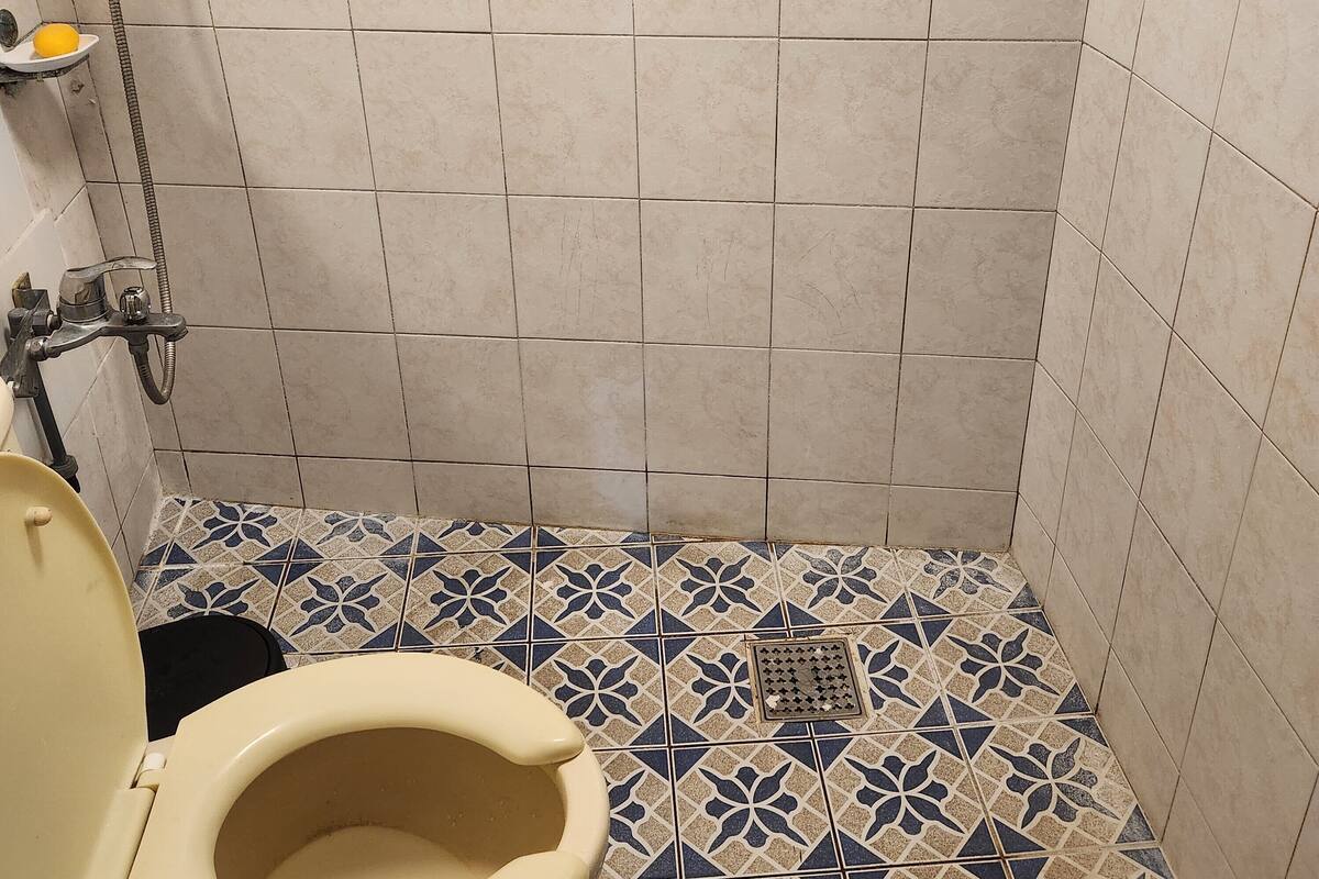 A bathroom with a toilet, a shower, and a sink.