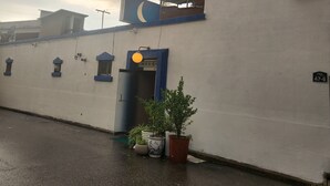 Ein Hostel namens Hostel Hanil mit einem Schild, einer blauen Tür und Pflanzen im Außenbereich.