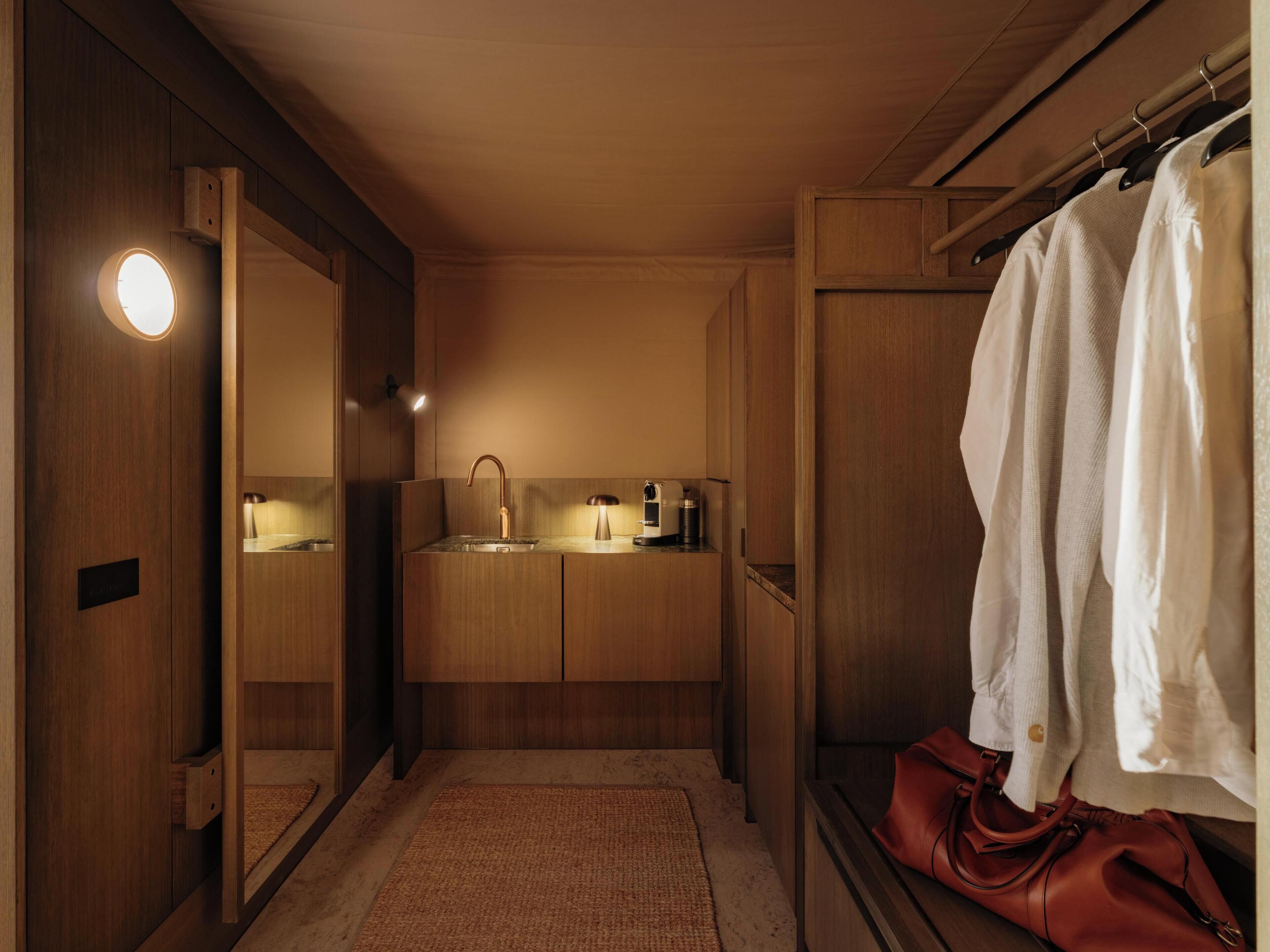 A modern bathroom with a wooden vanity, a sink, a mirror, and a towel rack.