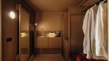 A modern bathroom with a wooden vanity, a sink, a mirror, and a towel rack.