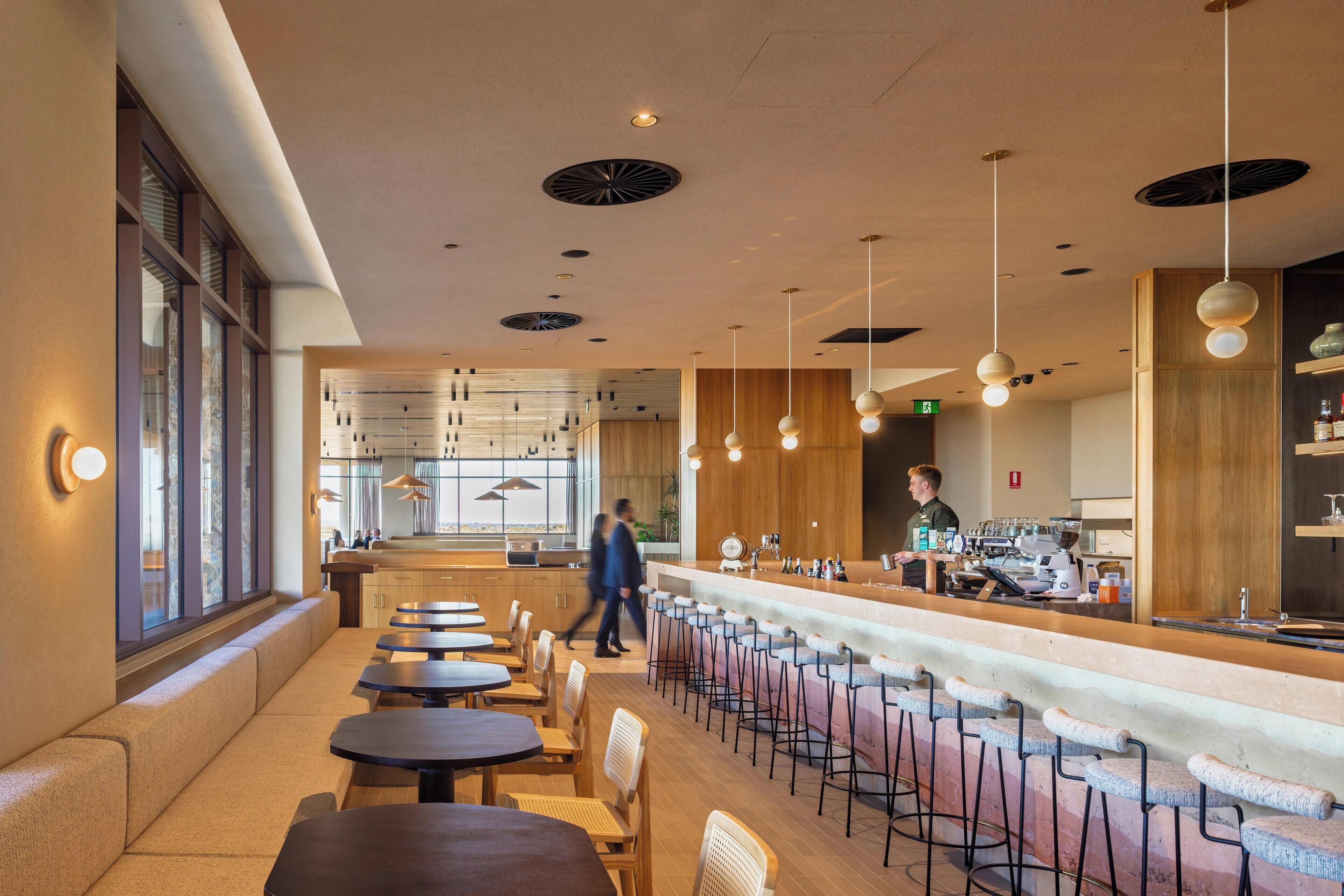 Zona bar moderna con posti a sedere e un bancone.