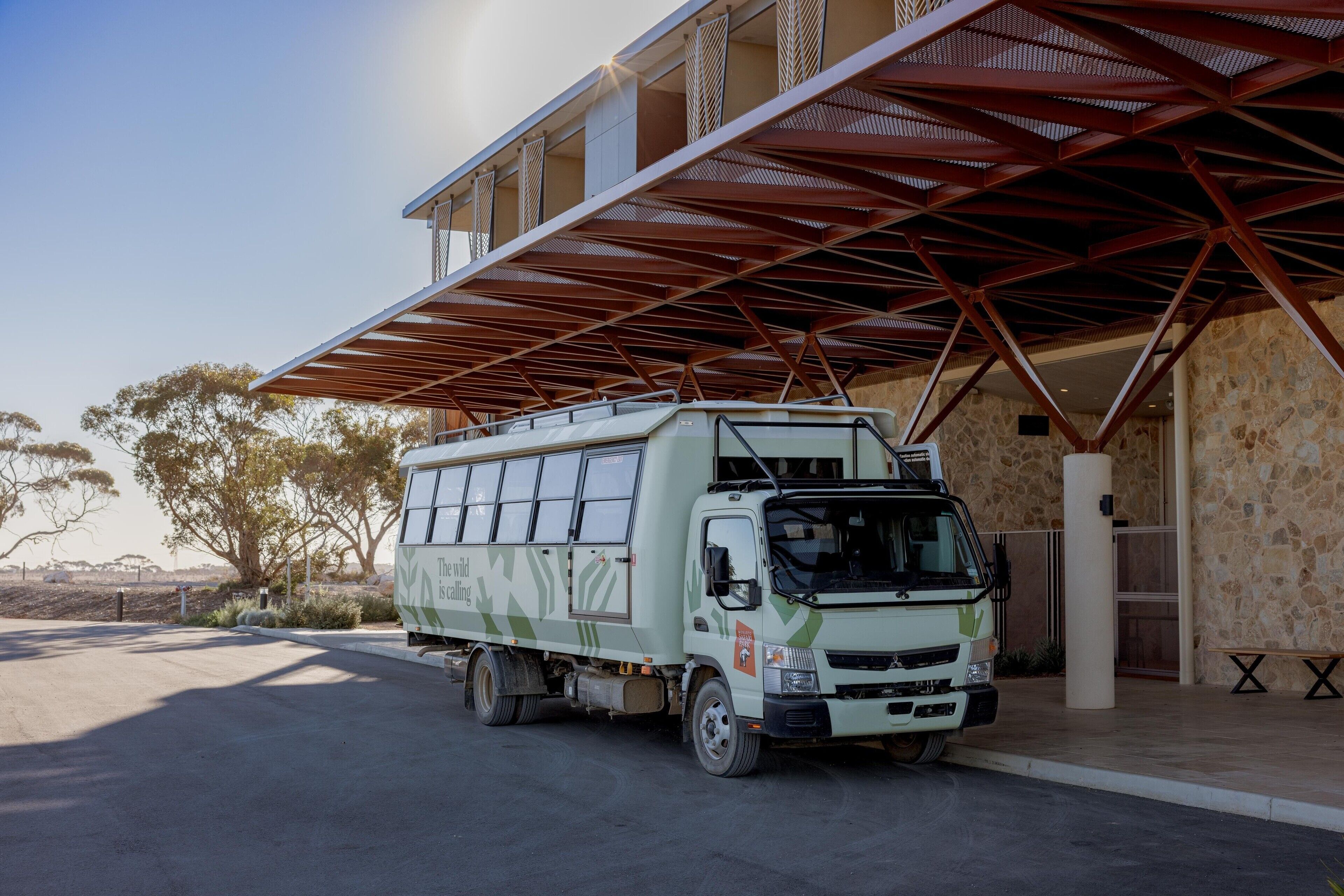 A white truck parked under a metal roof structure.