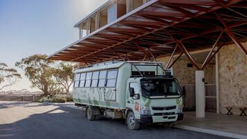 A white truck parked under a metal roof structure.
