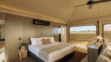 A bedroom with a bed, bedside table, lamp, and a ceiling fan.