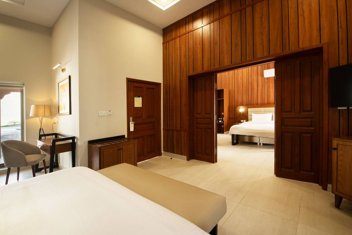 Une chambre d’hôtel équipée d’un lit, d’un bureau, d’une chaise, d’une armoire et offrant une vue sur l’extérieur.