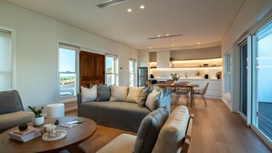 A spacious living area with a sofa, coffee table, and a dining area with chairs. - Luxury Coastal Vineyard Escape | Fig View | Crooked River Estate (Gerringong)